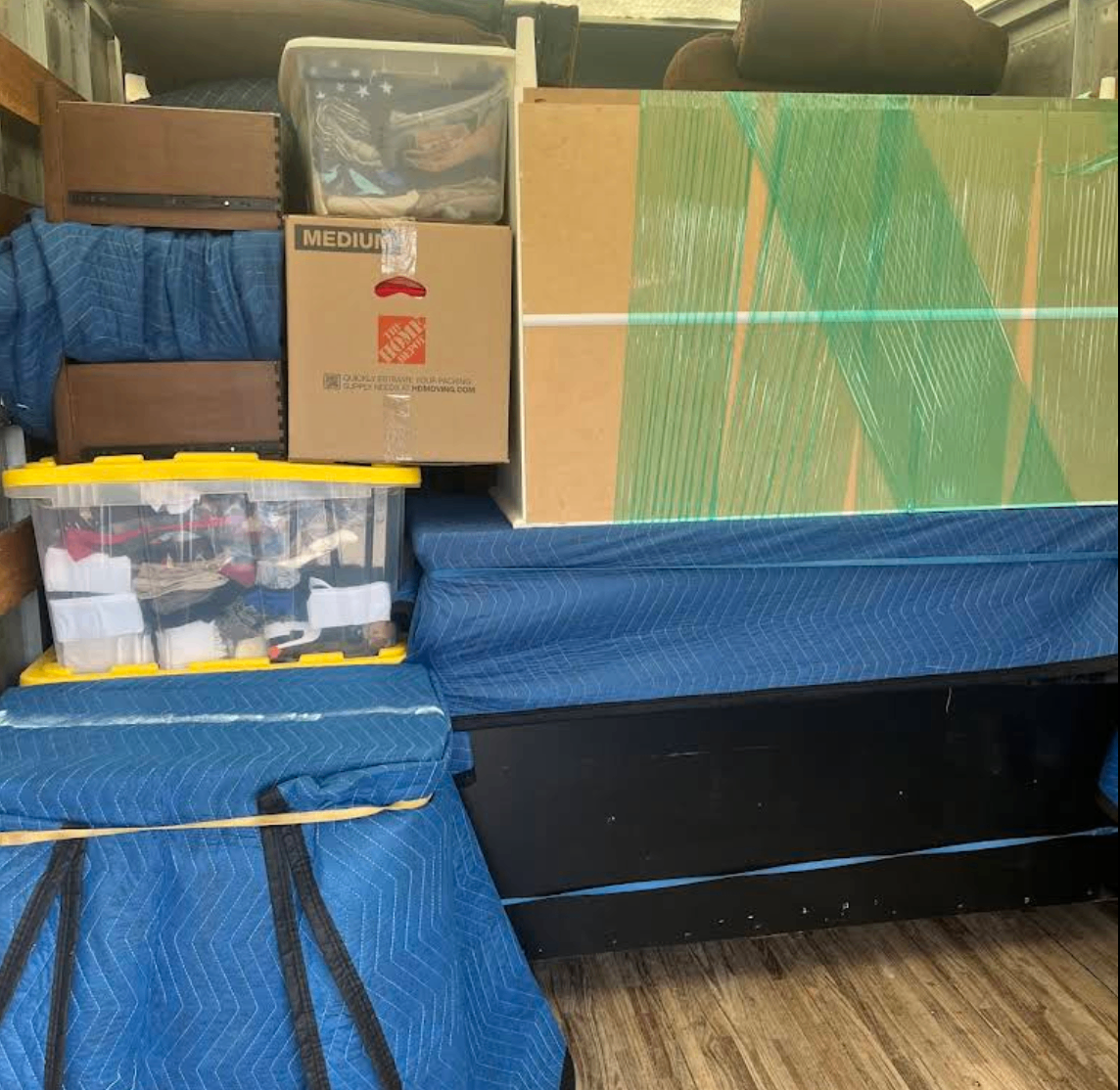 Dressers and household items secured with padding and wrap inside the moving truck