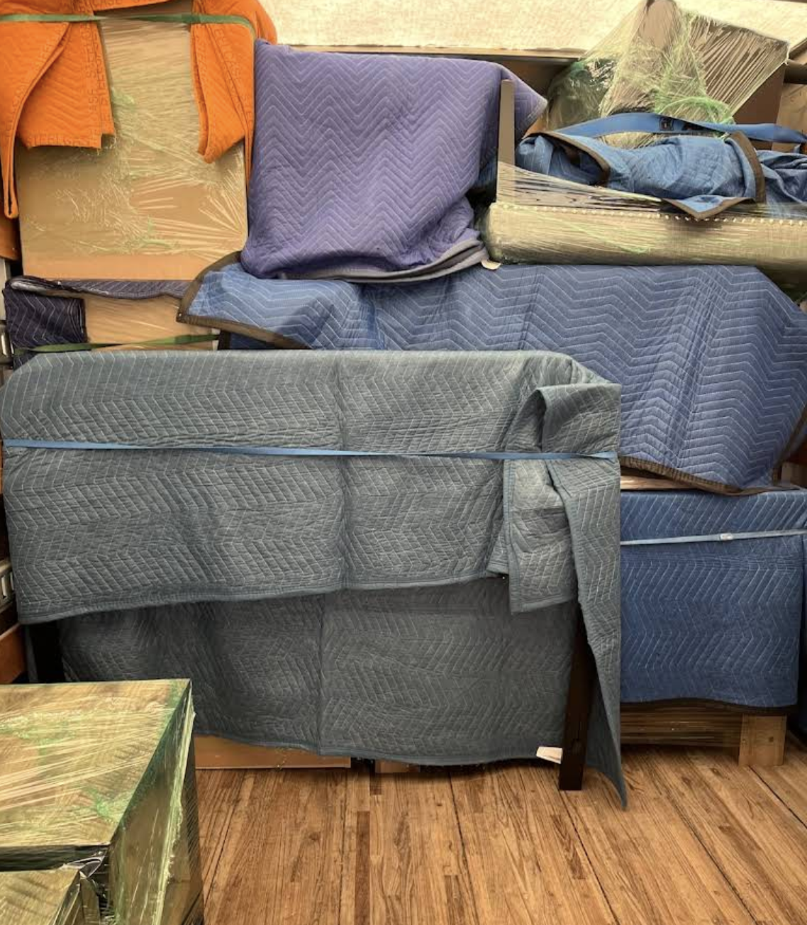 Wrapped furniture and large household pieces padded and secured inside a moving truck