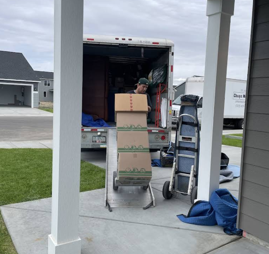 Boxes being unloaded down the moving truck ramp at a home