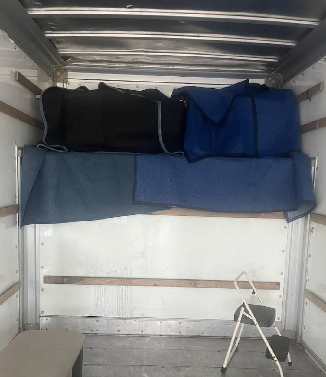 Moving blankets and protective pads stored neatly inside a truck and ready for use