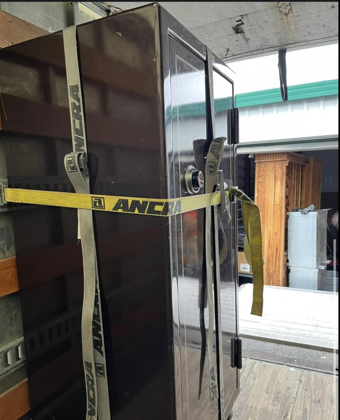 A large safe professionally strapped and secured inside a moving truck